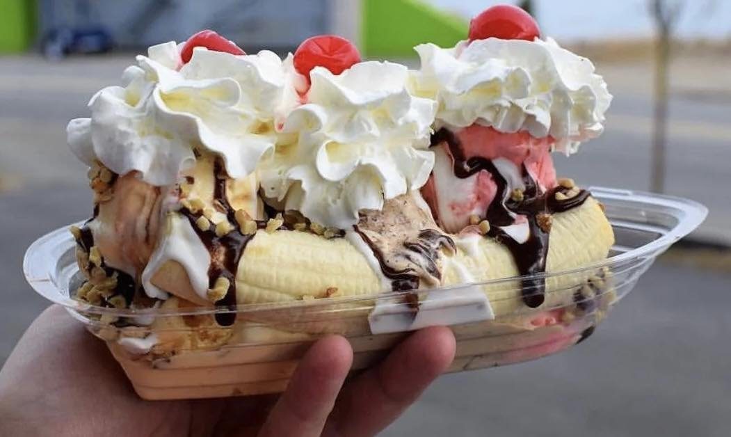 Banana split with whipped cream and cherries
